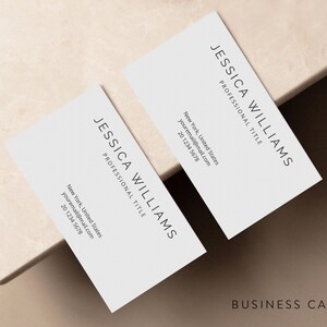 May include: A white business card with black text. The text reads "JESSICA WILLIAMS" and "PROFESSIONAL TITLE". The card also includes contact information, including an email address and phone number.