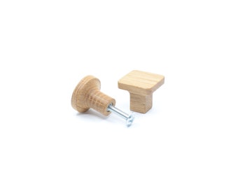 May include: Two wooden cabinet knobs, one round and one square, with a silver screw.