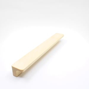 Pode incluir: Uma puxador de armário de madeira bege claro com forma retangular e uma ligeira curva na parte inferior.