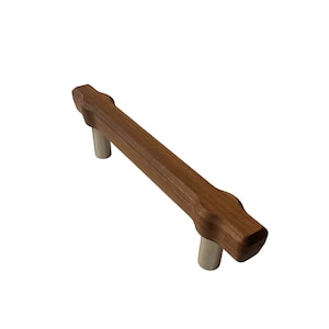 May include: A wooden cabinet pull with a rectangular, brown body and rounded ends. The pull has two silver-colored metal posts for mounting. The hardware is designed for use on drawers or cabinet doors.