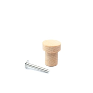 Könnte beinhalten: Ein Holz-Knopf mit runder Oberseite und zylindrischer Basis. Er wird mit einer silbernen Schraube geliefert.