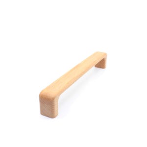 Peut inclure: Une poignée de tiroir en bois de couleur brun clair de forme rectangulaire.