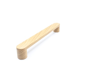 May include: A light brown wooden cabinet pull with rounded ends.