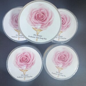 May include: Five round white labels with a pink rose illustration and gold lettering. The labels read "PH Pleaser Probiotic Yoni Soap Bar".