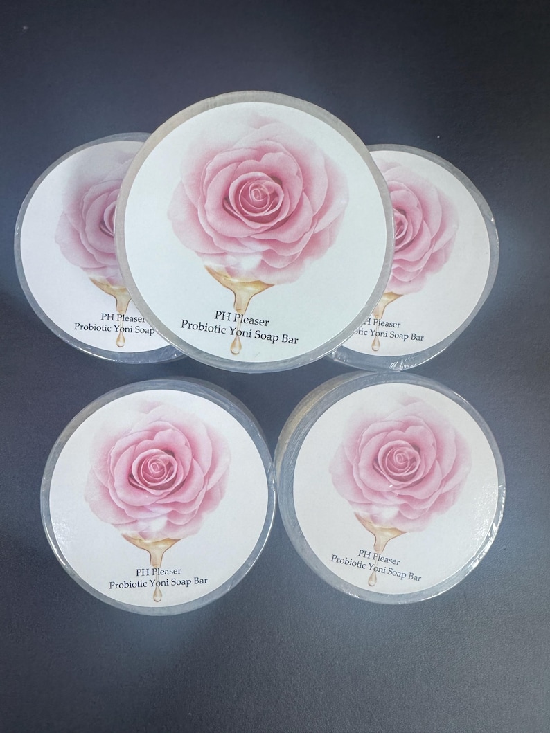 May include: Five round white labels with a pink rose illustration and gold lettering. The labels read "PH Pleaser Probiotic Yoni Soap Bar".