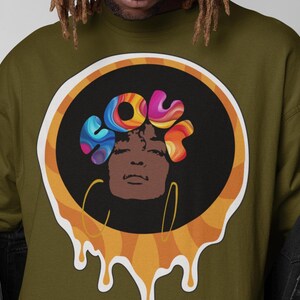 May include: A green sweatshirt with a circular design featuring a psychedelic graphic of a woman's face with the word "SOUL" in colorful, swirling letters. The design has a dripping effect, creating a retro, 1970s aesthetic.