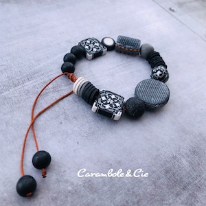 Shamballa bracelet of hand-modeled beads in polymeric paste imitation black jeans and cement tiles unique model