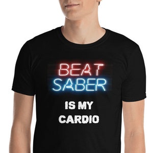 Może przedstawiać: Czarny T-shirt z napisem "BEAT SABER IS MY CARDIO" w neonowych niebieskich i czerwonych literach.