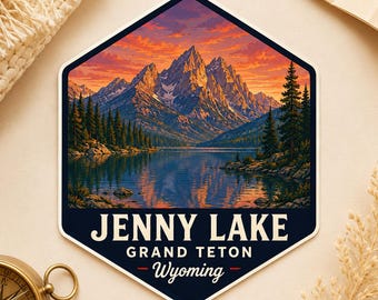 May include: A hexagonal sticker featuring a landscape illustration of Jenny Lake in Grand Teton, Wyoming. The scene depicts snow-capped mountains under a vibrant orange sunset sky, reflected in the calm lake water, with pine trees along the shore.