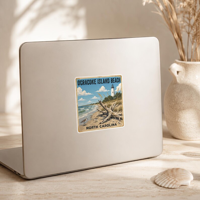 May include: A square sticker featuring a vintage-style illustration of Ocracoke Island Beach, North Carolina. The scene depicts a white lighthouse, sandy dunes, driftwood, and two small birds on the shore under a blue sky with white clouds.