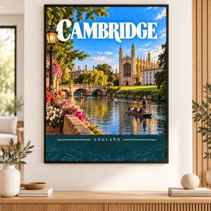May include: A framed wall art print featuring a scenic view of Cambridge, England. The image displays a stone bridge over a river, a historic gothic building, a black lamppost, colourful flowers, and a wooden boat with people. The text reads CAMBRIDGE.