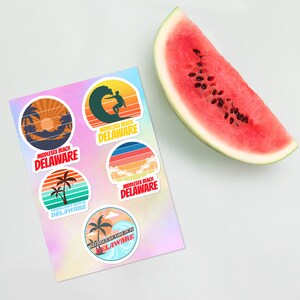 May include: Five round stickers with a retro design featuring a beach scene and the text "Middlesex Beach Delaware". The stickers are on a holographic background.