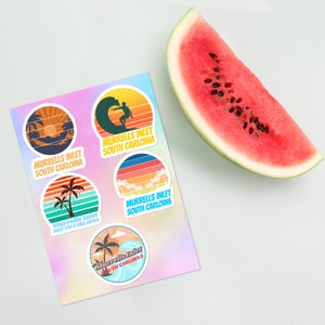 May include: Five colorful round stickers with a retro design featuring a sunset, palm trees, and a surfer. Each sticker says "Murrells Inlet South Carolina".
