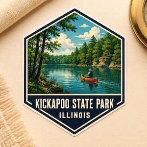 May include: A hexagonal sticker featuring a landscape illustration of a person paddling an orange canoe on a calm blue river, surrounded by green trees and rock formations under a blue sky with white clouds. The text reads KICKAPOO STATE PARK ILLINOIS.