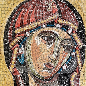 Può includere: Un'opera d'arte in mosaico che rappresenta il viso di una donna. Il viso della donna è composto da piccole tessere colorate e i suoi occhi sono chiusi. L'opera è incorniciata in una cornice dorata.
