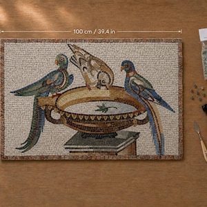 May include: A rectangular mosaic art piece measuring 100 cm by 64 cm (39.4 in by 25.2 in) featuring two blue birds perched on a golden bowl on a pedestal. Includes a bag of loose mosaic tiles, a metal palette knife, and red-handled nippers.