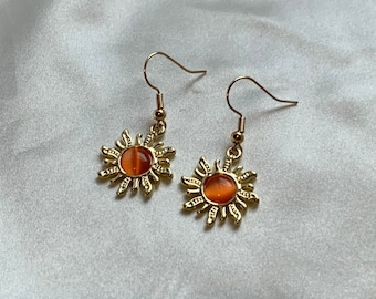 Pendientes de sol en color naranja dorado con centro naranja en ganchos chapados en oro de 18k