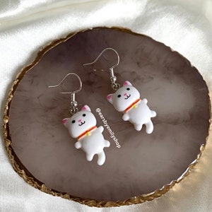 クールで風変わりな 3D の白い猫のドロップ ダングル イヤリング。シルバー メッキのフックに手作りされています。