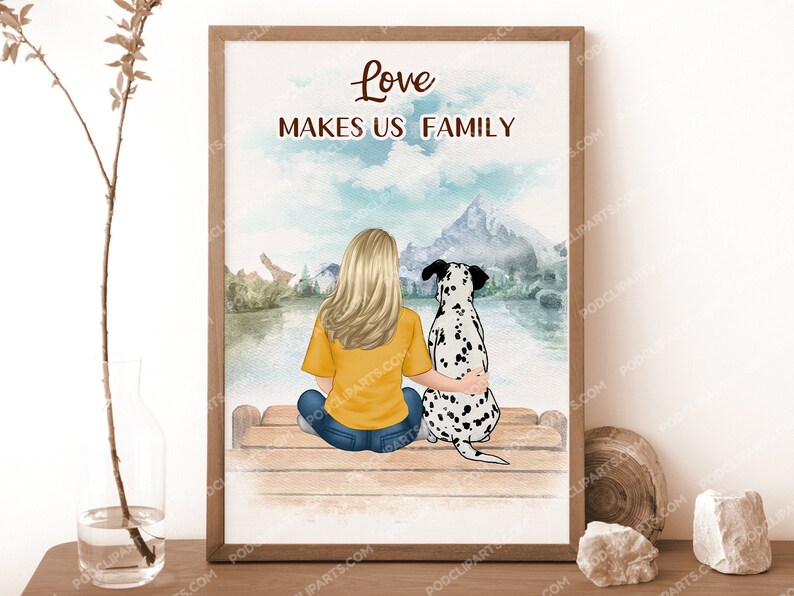 May include: A watercolor illustration of a woman and a dalmatian dog sitting on a wooden bench. The woman is wearing a yellow shirt and blue jeans. The dog is wearing a black collar. The background is a watercolor painting of a lake and mountains. The text "Love Makes Us Family" is written in black at the top of the image.