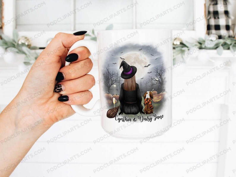 May include: White ceramic mug with a black and white illustration of a witch with a black cat and pumpkins. The text "Cynthia & Daisy Jane" is printed on the mug.