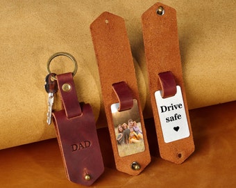 May include: Three leather keychains with different designs. One keychain has a photo of a family, another has the text "Drive safe" with a heart, and the third has the word "DAD" engraved on it.
