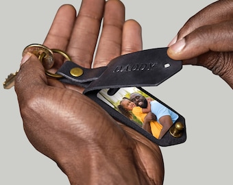 May include: Black leather keychain with a photo insert and the word "DADDY" embossed on the flap. A photo of a father and daughter is visible in the insert.