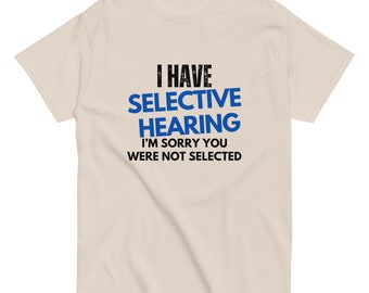 Może przedstawiać: Beżowa koszulka z napisem "I have selective hearing I'm sorry you were not selected" w kolorze czarnym i niebieskim.