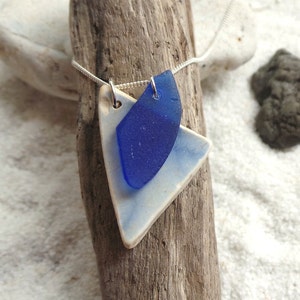 Collar de plata de primera ley con hermoso cristal de mar azul y detalle de cerámica de playa.