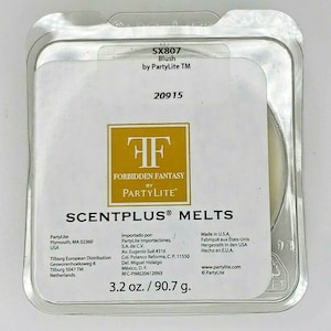 May include: A white plastic container with a clear window showing a wax melt. The container has the text "SX807 Blush by PartyLite TM" and "FORBIDDEN FANTASY BY PARTY LITE™" on it. The container also has the text "SCENTPLUS® MELTS" and "3.2 oz./90.7 g."