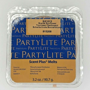 May include: A PartyLite Scent Plus wax melt in a clear plastic container with a yellow label. The label says "Scarlet Sunflower" and "Tournesol flamboyant" in English and French. The label also says "Scharlachrote Sonnenblume" in German. The label has the product number "SX1013" and the SKU "815208". The label also says "3.2 oz./90.7 g."