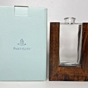 May include: A clear glass bottle with a wooden frame, packaged in a light blue box with the PartyLite logo.