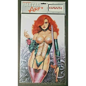 May include: A comic book cover featuring a woman with red hair, wearing a revealing outfit and holding a sword. The cover is labeled "METAL ART" and "DAWN". The artwork has a fantasy theme with detailed illustrations and a dark color palette.