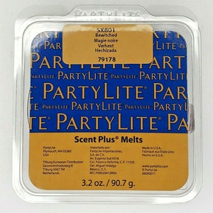 May include: A PartyLite Scent Plus Melts package in a clear plastic container. The label reads "Bewitched" and "Magie noire". The package contains 90.7 g of scented wax melts. The brand name "PartyLite" is visible.