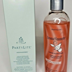 May include: A PartyLite Aroma Simmers liquid potpourri bottle with a guava and papaya scent. The bottle is clear and has a textured surface. The label is orange and features a guava and papaya illustration. The bottle is 11.8 fluid ounces or 350 milliliters.