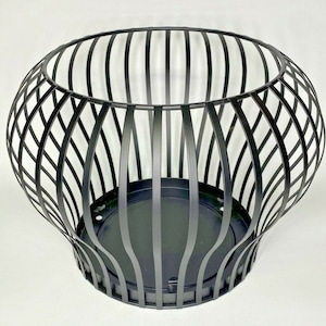 May include: Black metal planter with a round, open top and a wide, flared base. The planter has a wire mesh design.
