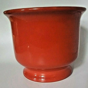 May include: A large, red ceramic planter with a wide, round base and a flared lip.