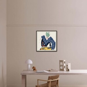May include: A framed abstract art print with a blue, yellow, red, and green color scheme. The print is set against a white wall in a minimalist home office setting.
