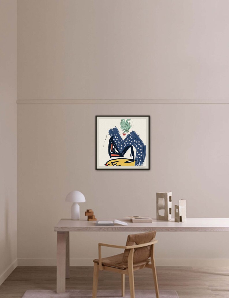 May include: A framed abstract art print with a blue, yellow, red, and green color scheme. The print is set against a white wall in a minimalist home office setting.