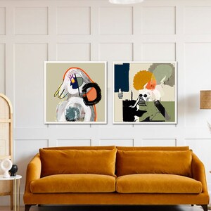May include: Two framed abstract art prints featuring colourful geometric shapes and figures. The prints are hung on a white wall above a mustard yellow velvet sofa.