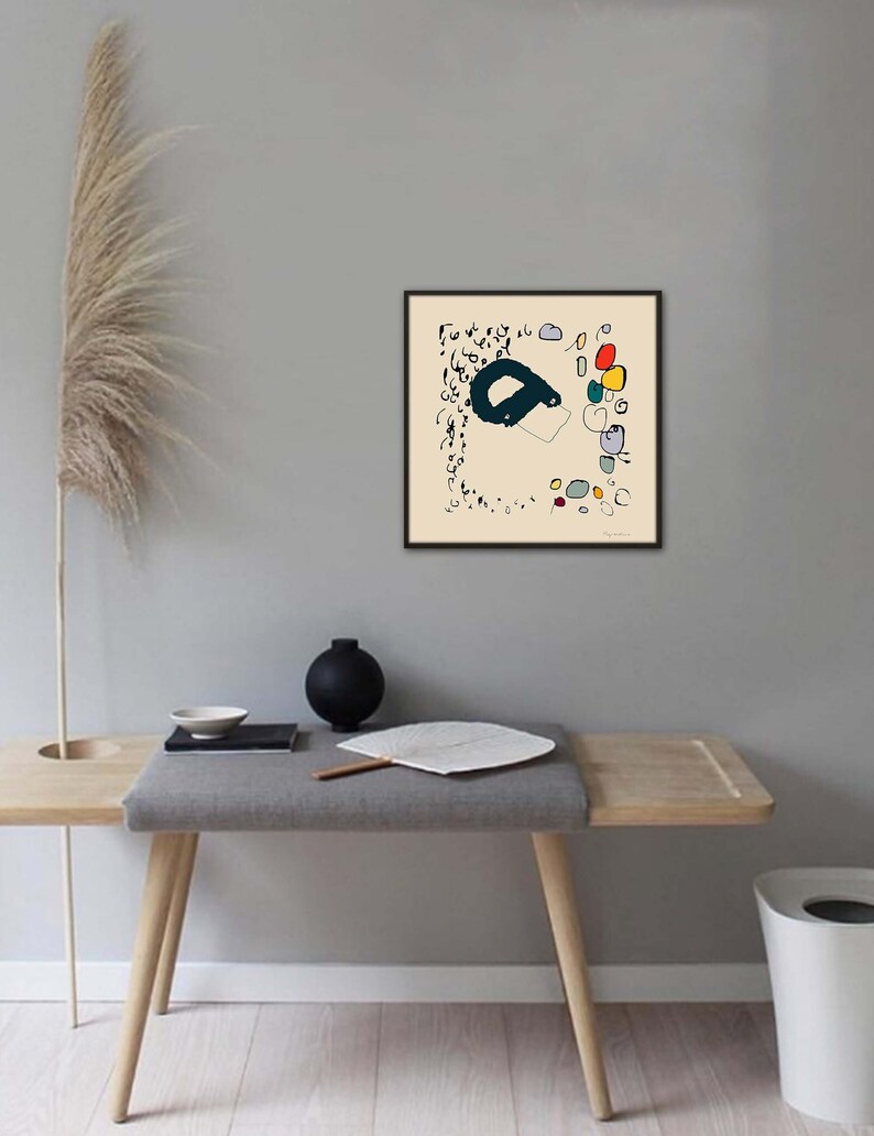 May include: A framed abstract art print with black lines and colorful shapes on a cream background. The print is in a black frame and is hanging on a gray wall.