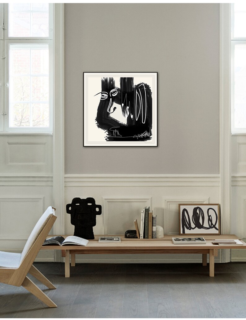 May include: Black and white abstract art print in a black frame. The print features a stylized face with bold lines and shapes.