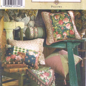 May include: A collection of decorative pillows with floral and checkered patterns. The pillows are in various shapes and sizes, with colors including green, pink, and blue. The image also includes the text "Simplicity HOME PILLOWS".