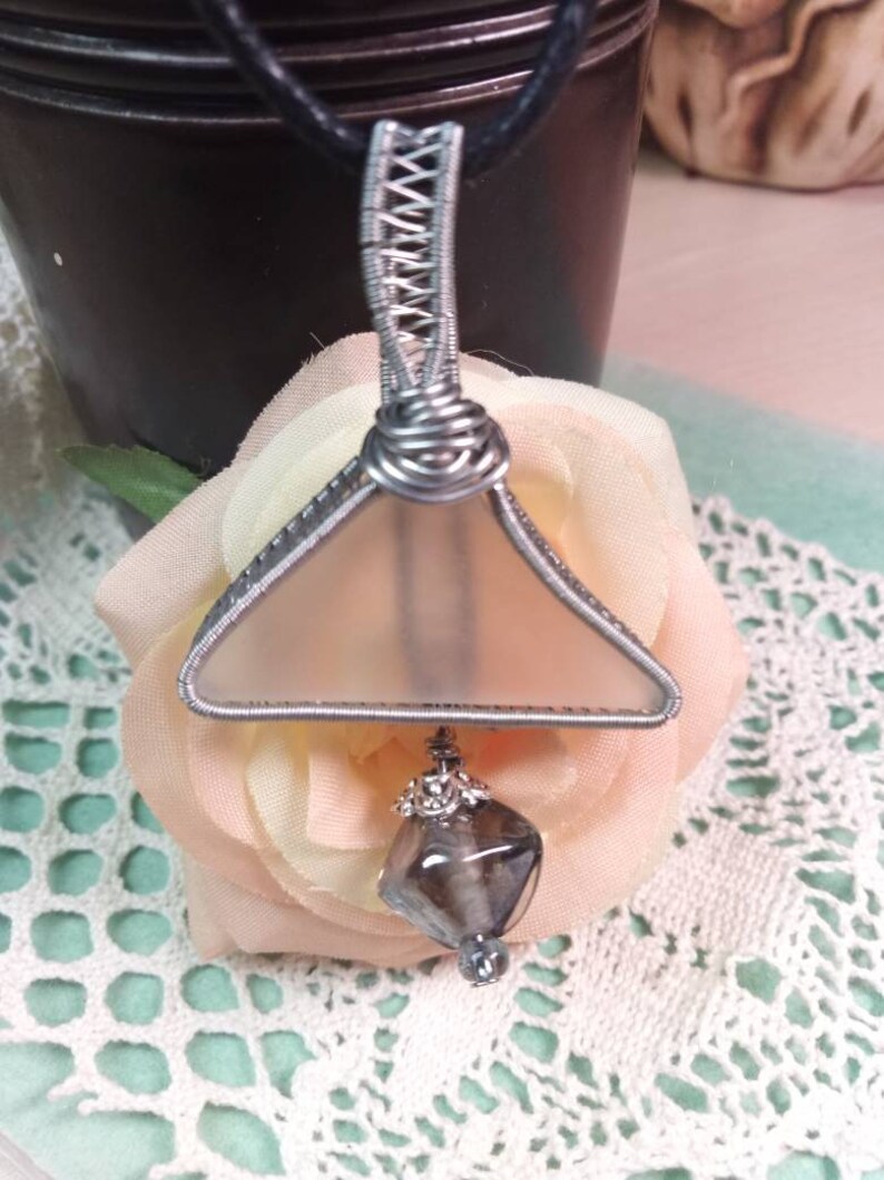 Unique triangular pendant with a pale sea glass wrapped in silver coated copper wire and a smokey glass bead dangling under.