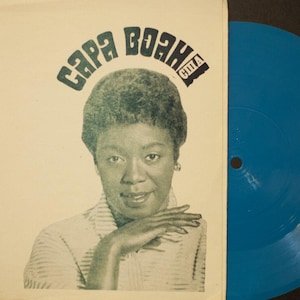 Könnte beinhalten: Ein Vintage-Vinyl-Plattencover mit einem Porträt einer Frau und dem Text "Sara Vaughan" in einer stilisierten Schrift. Der Text "США" ist ebenfalls auf dem Cover zu sehen.