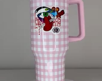 May include: A tall, cylindrical stainless steel tumbler with a pink and white gingham pattern, a pink handle, and a clear lid. The front features a colorful graphic of a stylized eye, a red tongue, and a dagger with the text "Lengua Mala".
