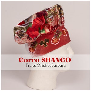 K&ouml;nnte beinhalten: Ein roter und goldener Satin-Kopftuch mit einem Blumenmuster und dem Text "Gorra SHANGO TrajesOrishasBarbara".