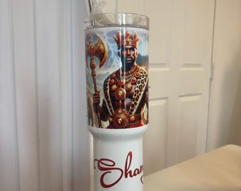 May include: A white stainless steel tumbler featuring a graphic of a king wearing a crown and leopard print cape while holding a golden axe. The lower portion of the tumbler displays the name "Sha" in red cursive script. A metal straw is included.