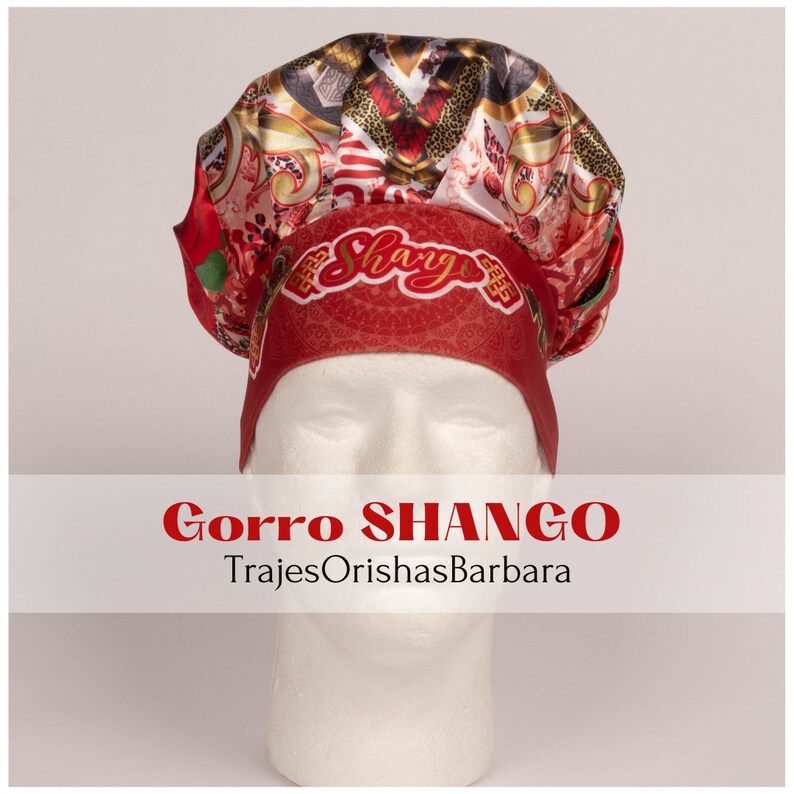 K&ouml;nnte beinhalten: Rote und goldene gemusterte Kochm&uuml;tze mit dem Wort "Shango" vorne bestickt. Die M&uuml;tze sitzt auf einem wei&szlig;en Mannequin-Kopf. "Gorra SHANGO" und "TrajesOrishasBarbara" stehen unter der M&uuml;tze.