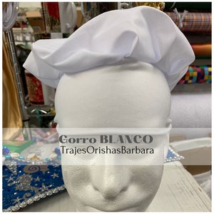 May include: White cotton chef's hat with the text "Gorro BLANCO TrajesOrishasBarbara" on the front.