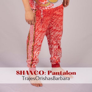 May include: Red and white patterned pants with a gold and black trim. The pants are called "SHANGO: Pantalon" and are made by "TrajesOrishasBarbara".